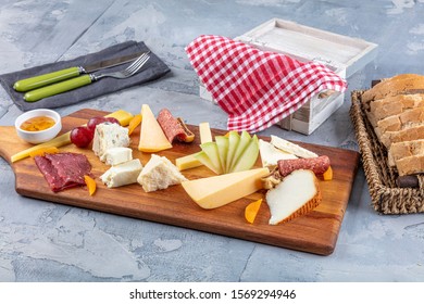 Cheese plate top view. Assorted cheeses Camembert, Brie, Parmesan blue cheese, goat. Served with sausage, bacon, grapes, figs, apples and apricots. - Powered by Shutterstock