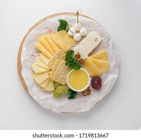 Cheese Platter All Sorts With Crunchy Crackers, Honey And Grapes Isolated On White Background. Top View. Snack And Appetizers