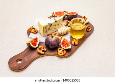 Cheese Platter (board) With Blue Cheese, Honey, Walnuts, Figs, Pretzels. Traditional Healthy Appetizer, Snack. Wooden Rustic Board On Stone Concrete Background, Copy Space