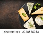 Cheese platter with craft cheese assortment at black background.