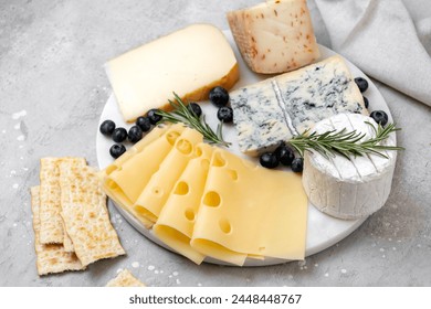 Cheese platter with craft cheese assortment on a marble platter. hard cheeses, mold cheese, gorgonzola, pecorino, Emmental, Roquefort - Powered by Shutterstock