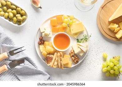 Cheese platter with different cheese and fruits on a white background. Top view. Appetizer for party. - Powered by Shutterstock