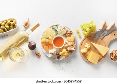 Cheese Platter With Different Cheese And Grapes,white Wine, Nuts, Olive, Figs On A White Background. View From Above. Festive Gourmet Appetizer.