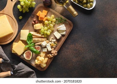 Cheese platter with grapes, nuts, figs, white wine on a brown background. Top view. Copy space. Appetizer for festive party. - Powered by Shutterstock