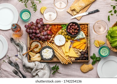 Cheese Platter For Summer Outdoor Party, Top Down View Of Rustic Table Setting With Various Kinds Of Cheese And Rose Wine