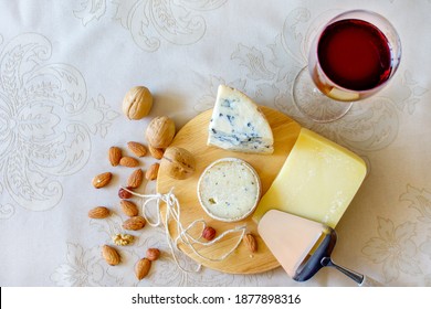 Cheese Platter With Three Types Of Cheese, Nuts, Glass Of Red Wine, And Cheese Slicer. Top View. Cognitive Decline Prevention Concept