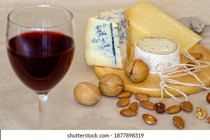 Cheese Platter With Three Types Of Cheese, Nuts, Glass Of Red Wine, And Cheese Slicer. Front View. Cognitive Decline Prevention Foods