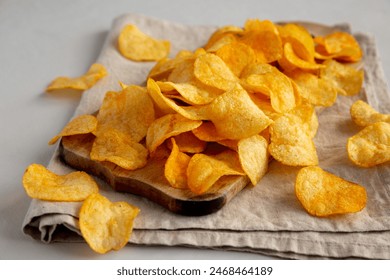 Cheese Potato Chips on a Wooden Board, side view.