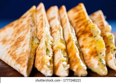 Cheese quesadilla on wooden board. Blue background - Shutterstock ID 1777248221