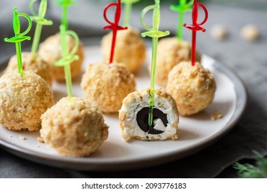 Cheese snack: cheese balls on skewers on a gray plate. Close-up. Canapes on cheese skewers on a gray background