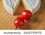 Cheese and tomatoes on wooden desk. Close-up shoot.