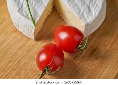 Cheese and tomatoes on wooden desk. Close-up shoot.