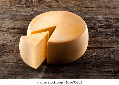 Cheese Wheel On Wooden Table