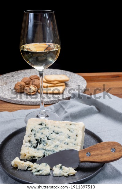 Cheese and\
wine pairing, french soft blue roquefort cheese and sweet white\
sauternes wine from Bordeaux, France, close\
up