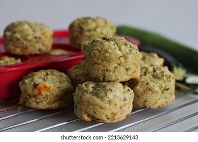 Cheese Zucchini Breakfast Muffins. Savory Breakfast Muffins Made Of Whole Wheat Flour, Shredded Zucchini, Grated Cheese And Herbs. Shot On White Background With Muffins Inside The Red Silicon Mould.
