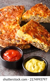 Cheeseburger Pie With Ground Beef Cheddar Cheese And Onion Close-up On A Slate Board On The Table. Vertical
