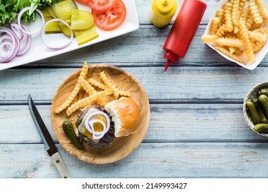 A Cheeseburger Slider On A Wooden Plate Served With French Fries.