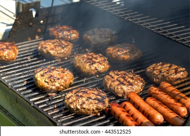 Cheeseburgers, hamburgers and hotdogs being grilled