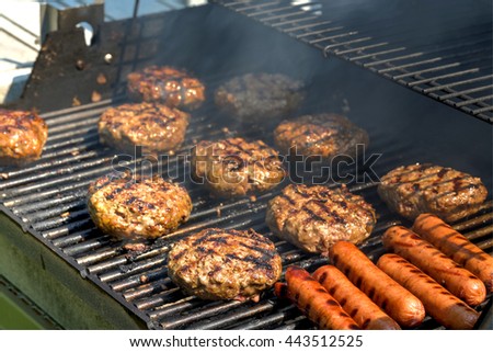 Cheeseburgers, hamburgers and hotdogs being grilled