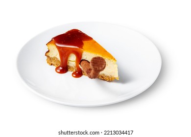 Cheesecake With Caramel And A Chocolate Nail Stuck Inside In A Plate On A White Background