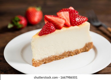 Cheesecake with strawberries on plate, wooden table background