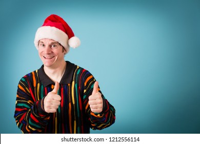 Cheesy Christmas Guy Posing In Ugly Sweater And Santa Hat