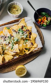 Cheesy Nacho Chips Platter With Avocado Sauce And Salad. Sharing Homemade Mexican Comfort Food With Friends And Family. Cooking A Vegetarian Healthy Snack At Home. Casual Lifestyle.