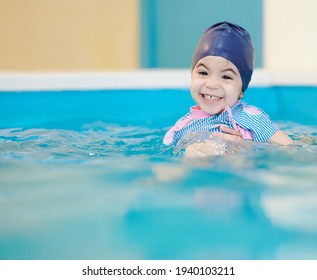 Cheesy Smile Of Girl In Swimming Pool On Blurred Water Background. Swim Classes Theme