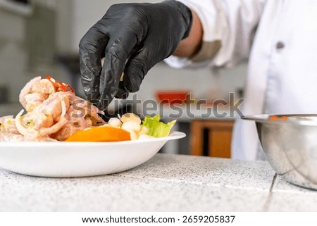Chef adding final touch of cilantro to a plate of peruvian ceviche, a traditional seafood dish