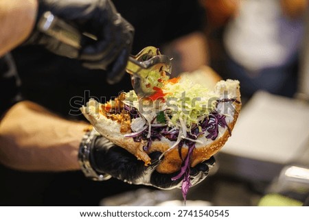Chef Adding Tomatoes to Doner Kebab Sandwich