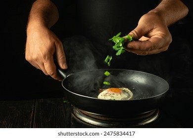 The chef adds chopped parsley to the pan with the eggs by hand. Concept of cooking lunch with egg in restaurant kitchen. - Powered by Shutterstock