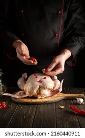 Chef Adds Red Viburnum To The Broiler Chicken Before Roasting. Cooking National Dishes In The Kitchen Of The Restaurant Or Hotel