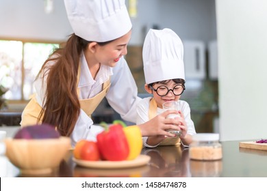 Chef Asian Mom Helping Little Son Drinking Milk For Healthy In The Kitchen Room At Home Happy Family Lifestyle.