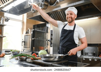 Chef of a Big Restaurant Prepares Dishes. Modern Kitchen is Made of Stainless Steel and Full of Cooking Ingredients. - Powered by Shutterstock