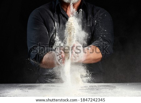 Similar – Foto Bild Koch in schwarzer Uniform schneidet ein Stück Brot ab.