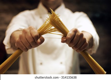 Chef breaking spaghetti with his hands