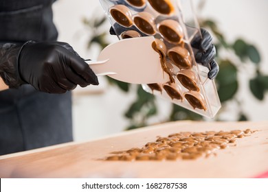 Chef Or Chocolatier Shakes Chocolate Molds For Sweets.