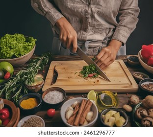 The chef is chopping fresh vegetables on a rustic table. - Powered by Shutterstock