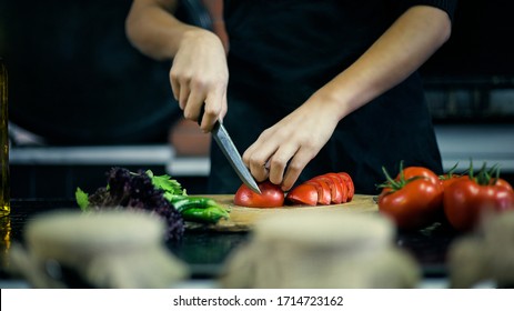 
A Chef Chopping Tomatoes With A Knife