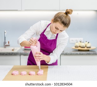 Chef With Confectionery Bag Squeezing  Cream To Parchment Paper At Pastry Shop Kitchen