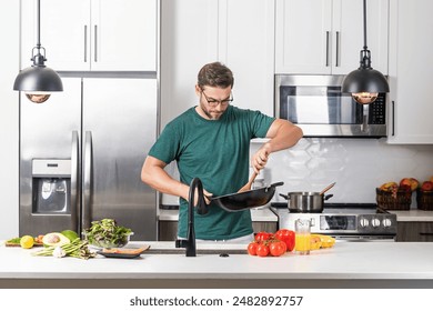 Chef cook cooking with pan at kitchen. Chef cook prepares with pan. Chef cooking with pan in modern kitchen. Mature chef man hold pan standing in kitchen, preparing food. - Powered by Shutterstock