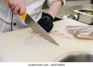 Chef  Or Cook Is Cutting Fish For A Seafood Dish In A Fancy Restaurant Kitchen