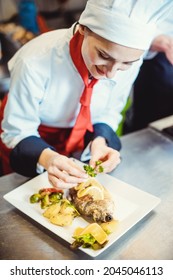 Chef Cook In A Fancy Restaurant Kitchen Finishing A Dish With Care