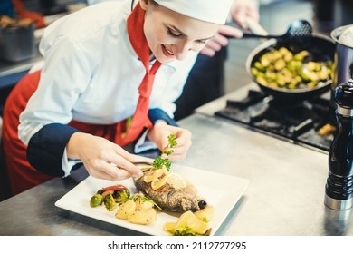 Chef Cook In A Fancy Restaurant Kitchen Finishing A Dish With Care