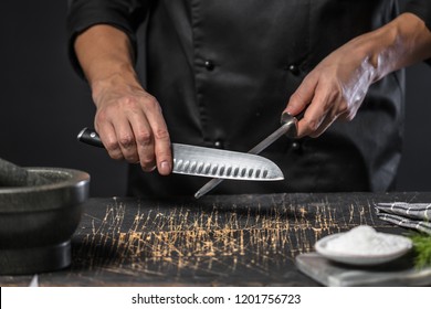 
Chef cook holds a knife over dark grey background. - Powered by Shutterstock