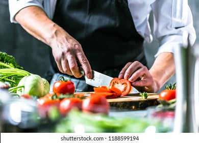 Chef cook preparing vegetables in his kitchen. - Shutterstock ID 1188599194