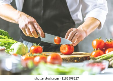 Chef cook preparing vegetables in his kitchen. - Shutterstock ID 1188599227