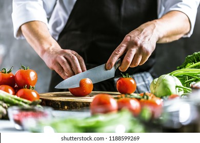 Chef cook preparing vegetables in his kitchen. - Shutterstock ID 1188599269