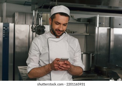 Chef cook using smart phone at the restaurant kitchen - Powered by Shutterstock