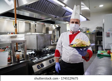 chef cook wearing face protective mask for corona virus disease with plate of authentic sandwich at professional restaurant kitchen. Health, safety distancing and pandemic in new normal concept
 - Powered by Shutterstock